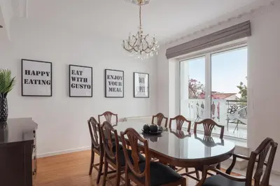 a dining room with a table and chairs and a chandelier at Athenian Secret Glyfada in Athens