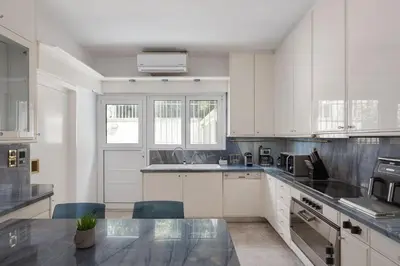 a kitchen with white cabinets and a counter top at Athenian Secret Glyfada in Athens