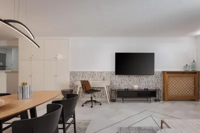 a dining room with a table and a television on a wall at Athenian Secret Glyfada in Athens