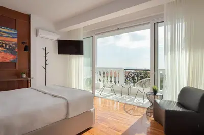 a bedroom with a bed and a balcony at Athenian Secret Glyfada in Athens