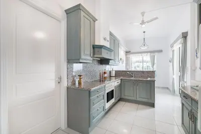 a kitchen with green cabinets and a white floor at Villa Asossa with Private pool & Sea view in Dhaskalión