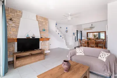 a living room with a couch and a tv at Villa Asossa with Private pool & Sea view in Dhaskalión