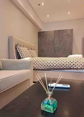 a living room with a bed and a vase on a table at ROYAL BLUE GRAND Suite No 4 Piraeus Port in Piraeus
