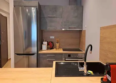 a kitchen with a stainless steel refrigerator and a sink at ROYAL BLUE GRAND Suite No 4 Piraeus Port in Piraeus
