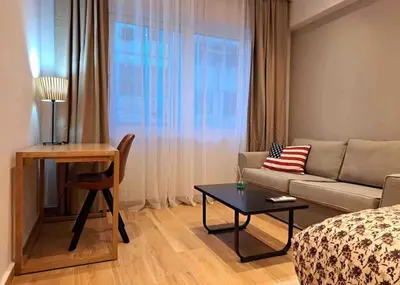 a living room with a couch and a table at ROYAL BLUE GRAND Suite No 4 Piraeus Port in Piraeus