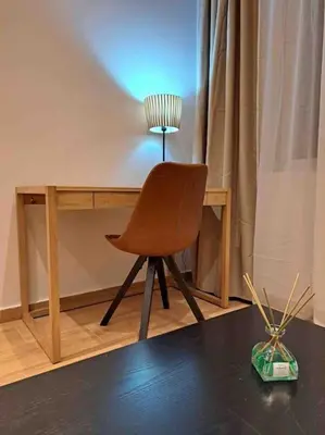 a chair sitting in front of a desk with a lamp at ROYAL BLUE GRAND Suite No 4 Piraeus Port in Piraeus