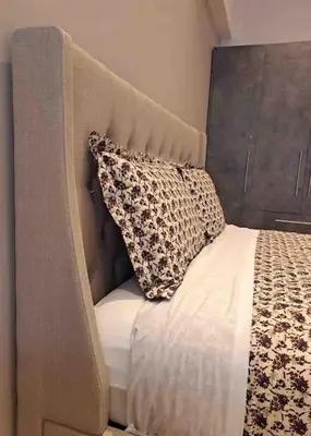 a bed with a headboard and a pillow on it at ROYAL BLUE GRAND Suite No 4 Piraeus Port in Piraeus