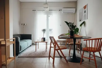 a living room with a table and chairs and a couch at Charming Apartment in Keramikos in Athens