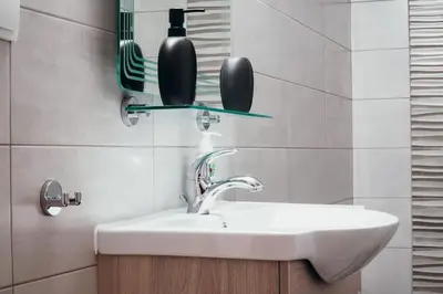 a bathroom with a sink and a bottle on a shelf at Charming Apartment in Keramikos in Athens