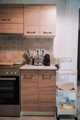 a kitchen with wooden cabinets and a stove at Charming Apartment in Keramikos in Athens