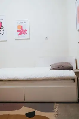 a bed in a bedroom with a white wall at Charming Apartment in Keramikos in Athens