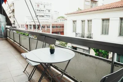 a white table and chairs on a balcony at Charming Apartment in Keramikos in Athens