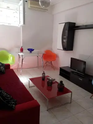 a living room with a red couch and a table at Kipseli house in Athens