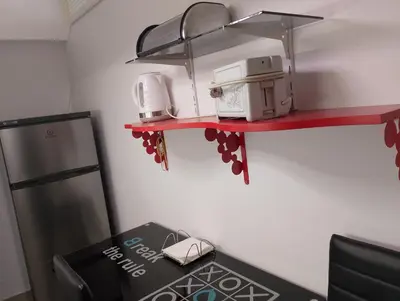 a kitchen with a red shelf with a stove and a microwave at Kipseli house in Athens