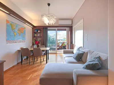 a living room with a couch and a table at Central Pagrati Apartment with Park View Balcony - opp Pangrati Grove in Athens
