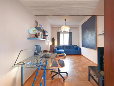 an office with a glass desk and a blue couch at Central Pagrati Apartment with Park View Balcony - opp Pangrati Grove in Athens