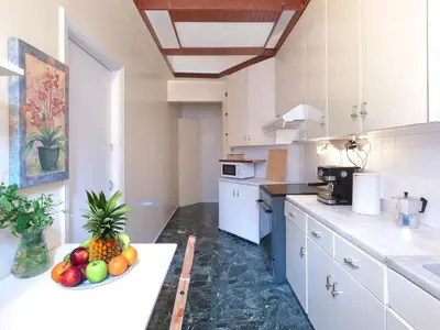 a kitchen with a bowl of fruit on a counter at Central Pagrati Apartment with Park View Balcony - opp Pangrati Grove in Athens