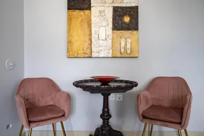 two chairs and a table in a room at Μercy suit in Piraeus