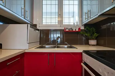 a kitchen with red cabinets and a sink at Μercy suit in Piraeus