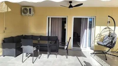 a living room with a couch and a table and chairs at Veta's Luxury apartment near the beach. in Lagonissi