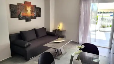 a living room with a couch and a table at Veta's Luxury apartment near the beach. in Lagonissi