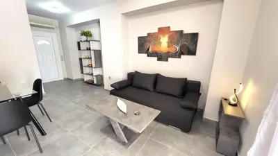 a living room with a couch and a table at Veta's Luxury apartment near the beach. in Lagonissi
