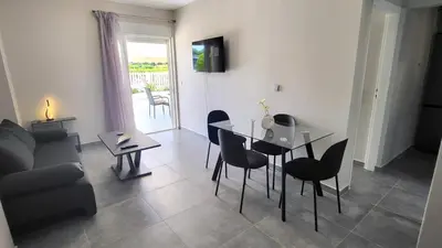 a living room with a table and chairs and a couch at Veta's Luxury apartment near the beach. in Lagonissi
