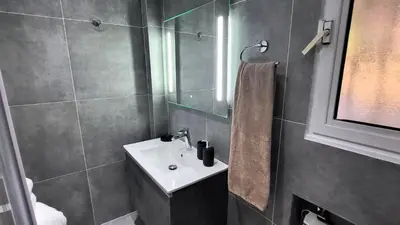 a bathroom with a white sink and a shower at Veta's Luxury apartment near the beach. in Lagonissi