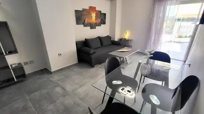 a living room with a couch and a table at Veta's Luxury apartment near the beach. in Lagonissi