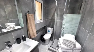 a bathroom with a toilet and a sink and a shower at Veta's Luxury apartment near the beach. in Lagonissi