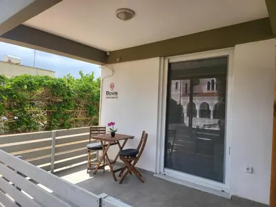 a patio with two chairs and a table on a balcony at Bovis Apartments #2 in Porto Rafti