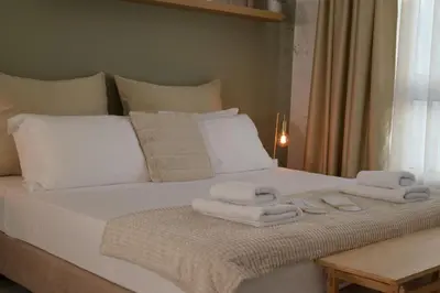 a white bed with towels on top of it at Athens Host - Harmony in Athens