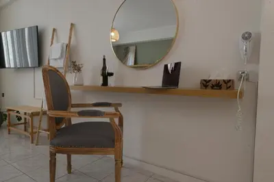a mirror and a chair in a room at Athens Host - Harmony in Athens