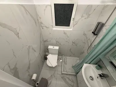 a bathroom with marble walls and a sink and a window at Athens Host - Harmony in Athens