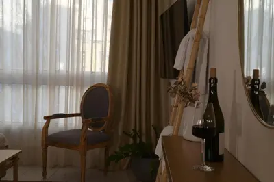 a room with a chair and a table and a window at Athens Host - Harmony in Athens