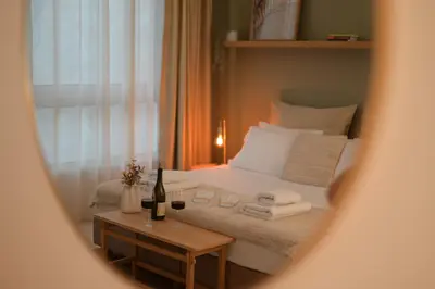 a bedroom with a bed and a table with a bottle of wine at Athens Host - Harmony in Athens