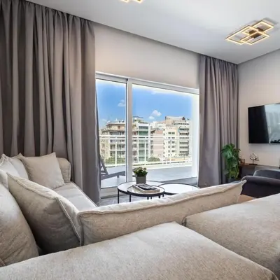 a living room with a couch and a large window at Parthenon view luxury penthouse in Athens