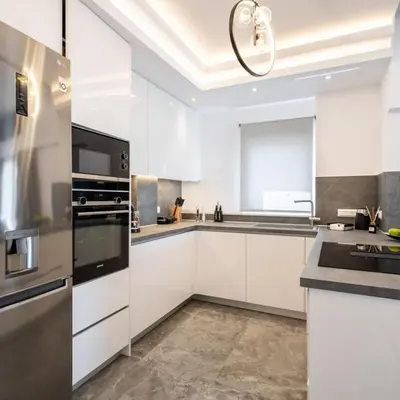 a kitchen with white cabinets and stainless steel appliances at Parthenon view luxury penthouse in Athens
