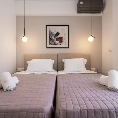 two beds sitting next to each other in a bedroom at Parthenon view luxury penthouse in Athens