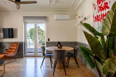 a dining room with a table and chairs and a plant at DIOS Zeus Temple View 1 Bedroom Apartment in Athens