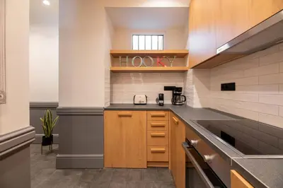a kitchen with wooden cabinets and a counter top at DIOS Zeus Temple View 1 Bedroom Apartment in Athens