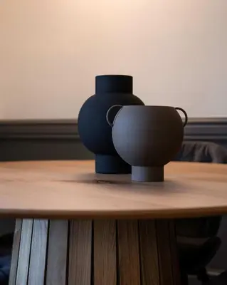 a black vase sitting on top of a wooden table at DIOS Zeus Temple View 1 Bedroom Apartment in Athens