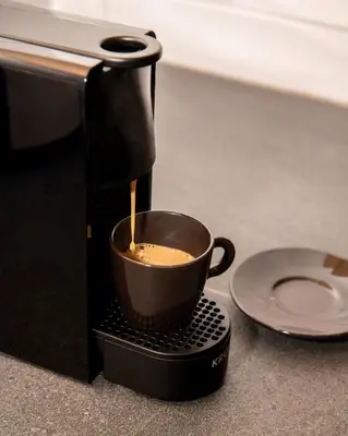 a coffee maker is making a cup of coffee at DIOS Zeus Temple View 1 Bedroom Apartment in Athens