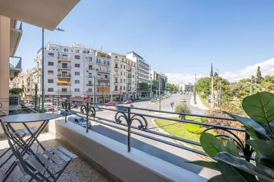 a balcony with a table and chairs and a street at DIOS Zeus Temple View 1 Bedroom Apartment in Athens