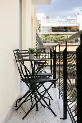 a table and chairs on a balcony with a plant at Athenian Modern & Luxury Apartments in Athens
