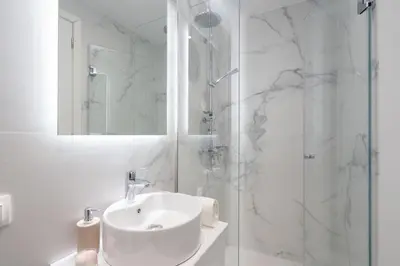 a white bathroom with a sink and a shower at Athenian Modern & Luxury Apartments in Athens