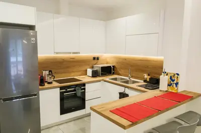 a kitchen with white cabinets and a stainless steel refrigerator at 2 br cozy stylish apartment in Athens