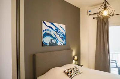 a bedroom with a bed and a painting on the wall at 2 br cozy stylish apartment in Athens