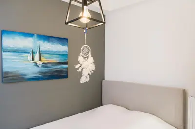 a bedroom with a bed and a painting on the wall at 2 br cozy stylish apartment in Athens
