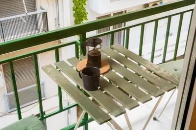 a table on a balcony with a coffee mug on it at 2 br cozy stylish apartment in Athens
